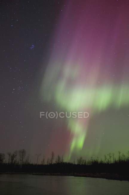 Luces boreales sobre el agua del lago - foto de stock
