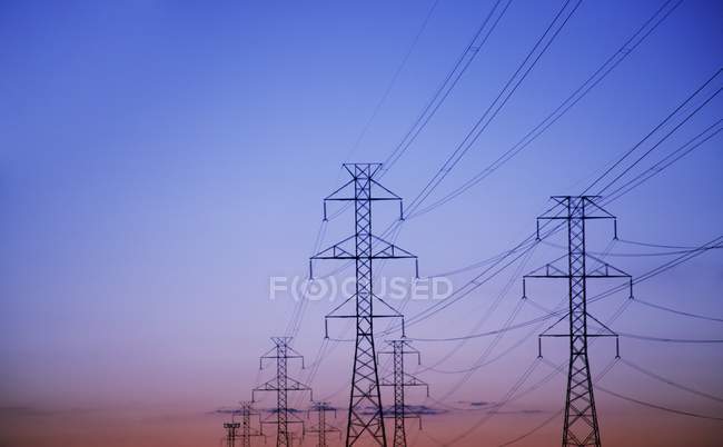 PILONI DI ELETTRICITÀ CONTRO IL SUNSET — Foto stock