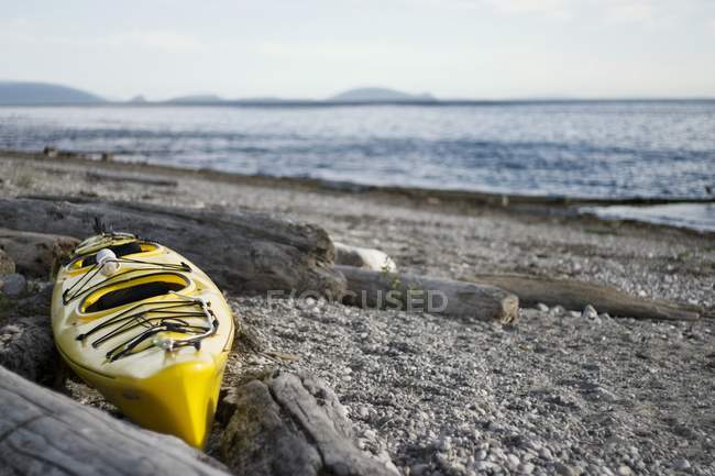 Kayak amarillo en la playa - foto de stock