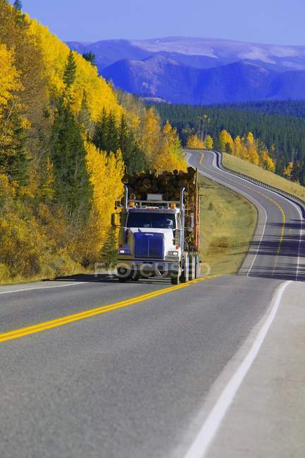 Camião de registo na estrada vazia. Alberta, Canadá — Fotografia de Stock