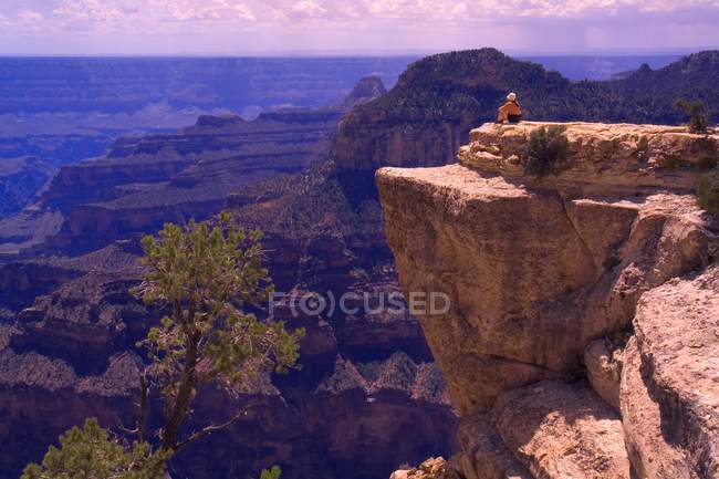 Сидя на обрыве скалы — стоковое фото