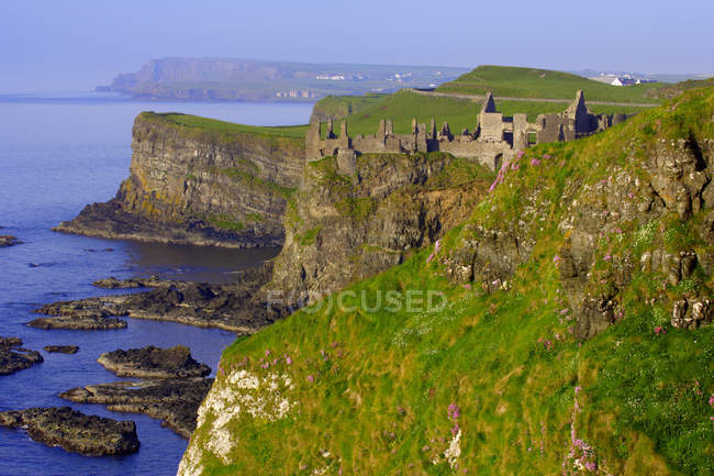 Building on cliff with green grass — Stock Photo