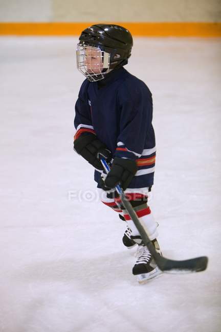 Criança jogando hóquei no gelo dentro de casa — Fotografia de Stock