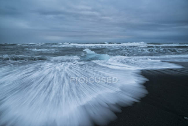 Plage de sable avec eau ondulée — Photo de stock