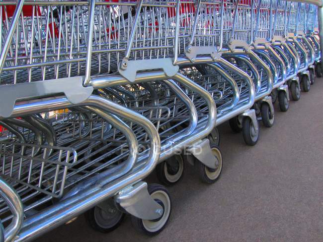Lote de carrinhos de compras colocados em fila no estacionamento — Fotografia de Stock