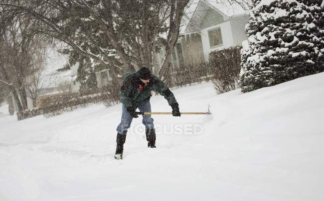 Mann mit Schaufel räumt Schnee auf Straße — Stockfoto