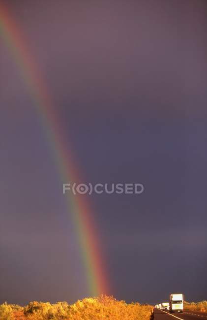 Arco iris contra el cielo ennegrecido - foto de stock
