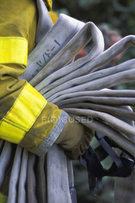 Pompiere che trasporta tubo vuoto — Foto stock