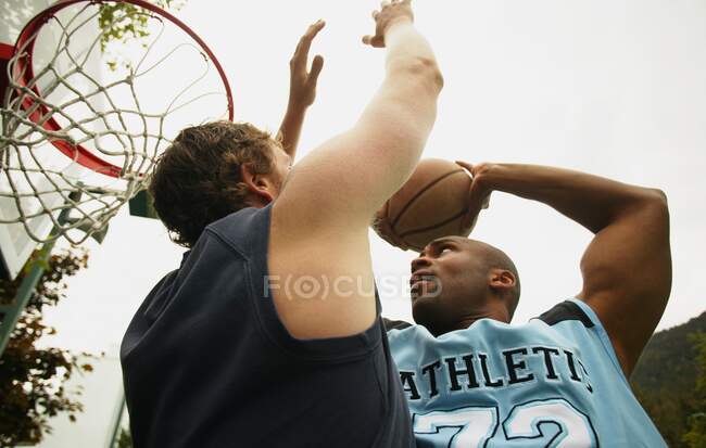 Низький кут зору чоловіків на баскетбол — стокове фото