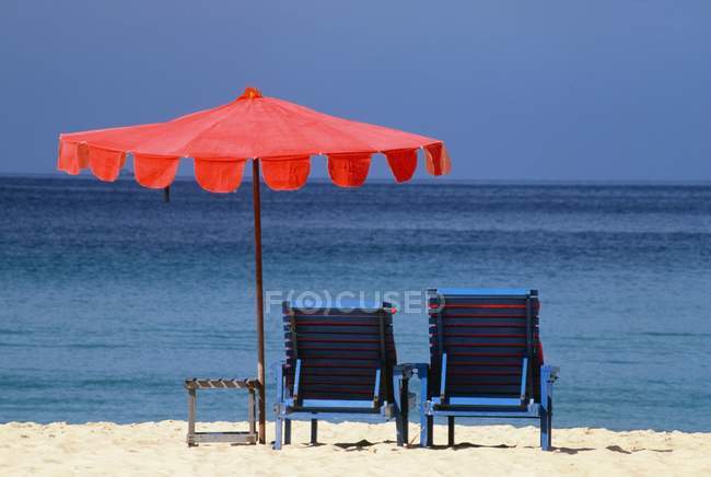 Стулья и зонтик на пляже — стоковое фото
