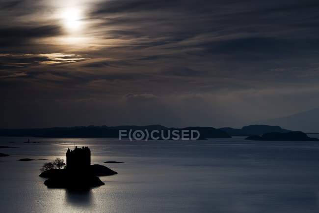 Замок на маленьком острове над водой — стоковое фото