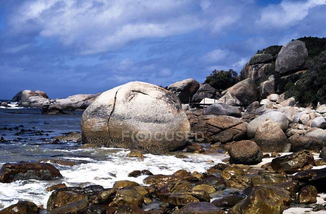Boulders Sur la plage contre l'eau — Photo de stock