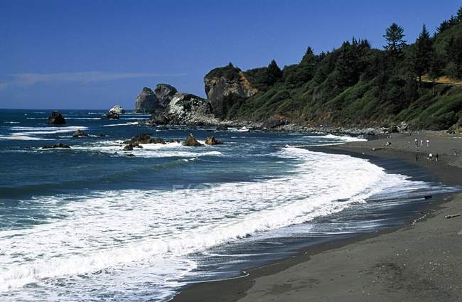 Praia de areia com água ondulada — Fotografia de Stock