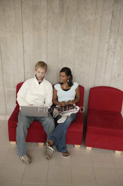 Caucasian man with black woman working together in office and sharing laptop — Stock Photo