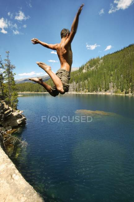 Saltar alto en el lago - foto de stock