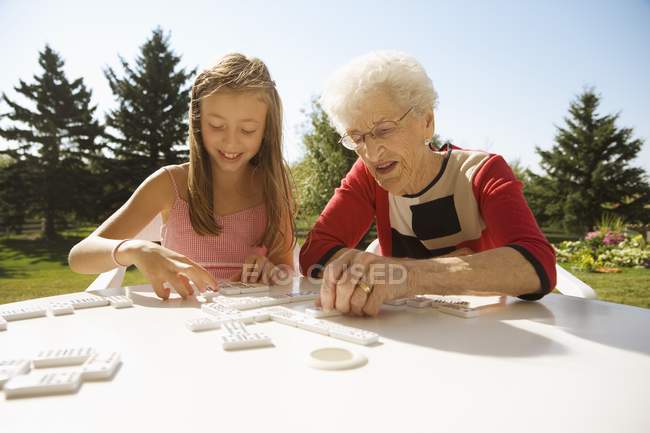 Großmutter und Enkelin spielen gemeinsam Dominospiel — Stockfoto