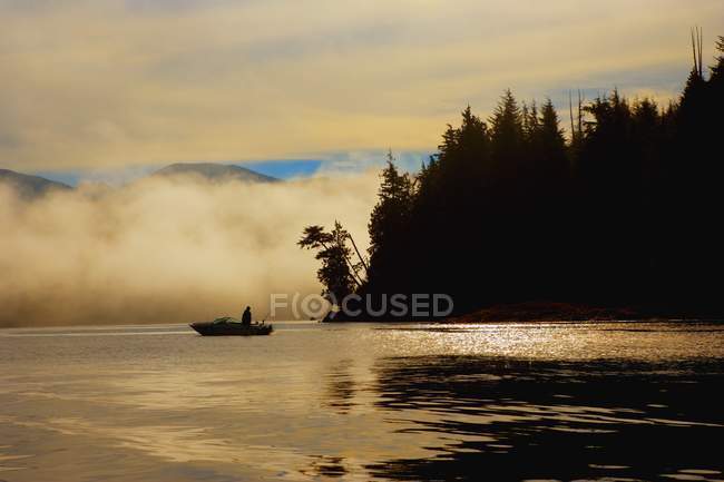 Pescador em barco sobre a água — Fotografia de Stock