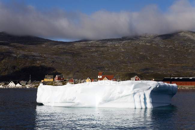 Iceberg en el agua con la ciudad - foto de stock
