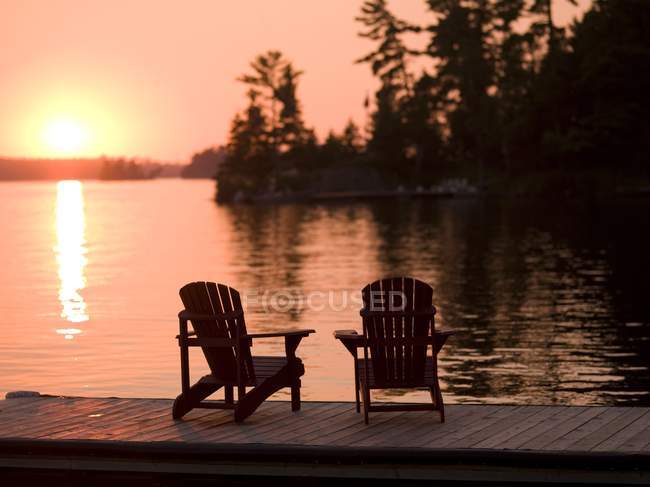 Wooden chairs on wooden pier — Stock Photo