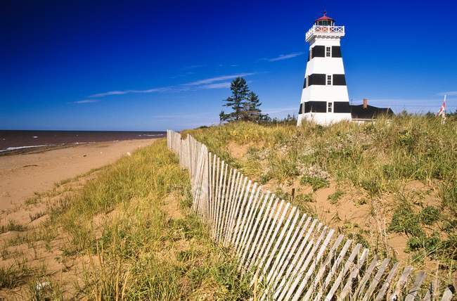 Lighthouse on sand beach — Stock Photo