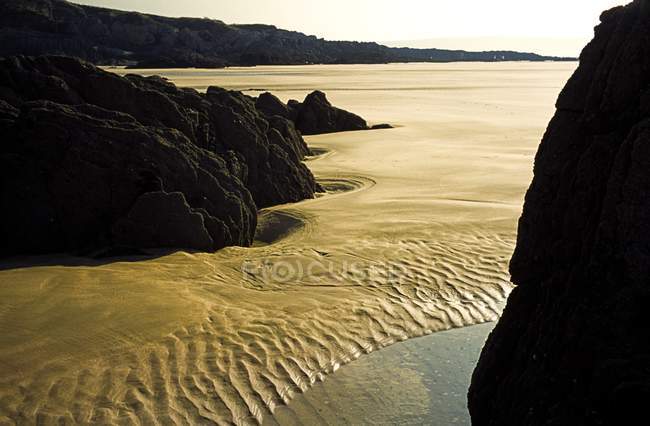 Onde increspature sulla spiaggia di sabbia — Foto stock