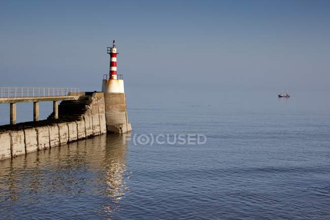 Faro sulla costa sopra l'acqua — Foto stock