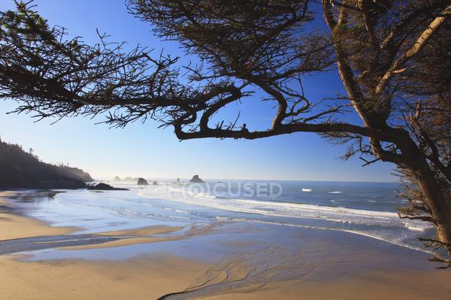 Песчаный пляж против волнистой воды — стоковое фото