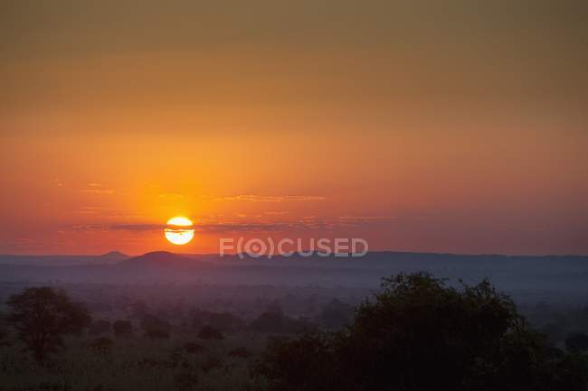 Захід сонця над полем з пагорбами — стокове фото