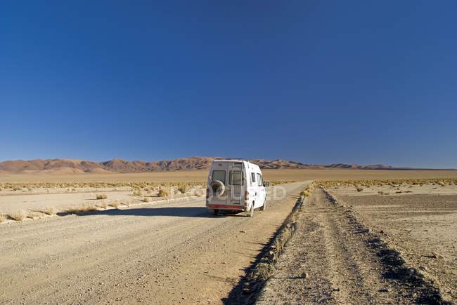 Кемпер Ван на пустынной дороге — стоковое фото