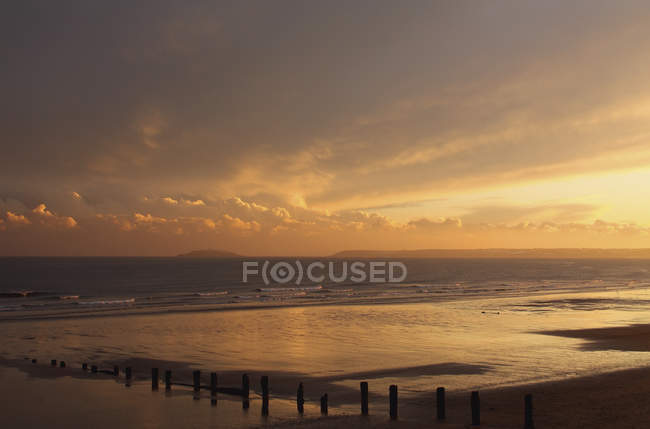 Pôr do sol sobre a praia no inverno — Fotografia de Stock