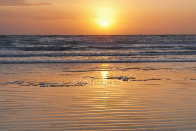 Схід сонця над розсікає хвилі — стокове фото