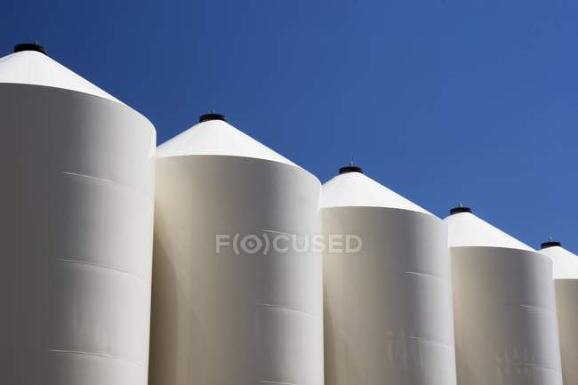 Большие белые металлические зерновые контейнеры — стоковое фото