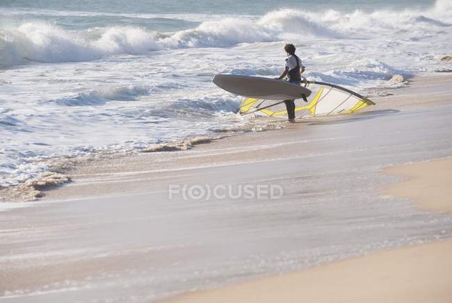 Hombre Windsurf en la playa - foto de stock