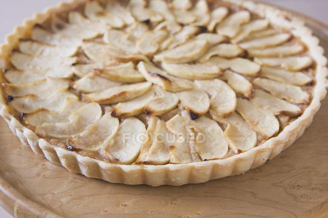 Baked apple tart on plate over wooden board — Stock Photo