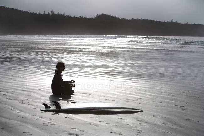 Surfer meditiert am Strand — Stockfoto