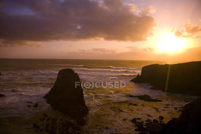 Скеляста берегова лінія на заході сонця — стокове фото
