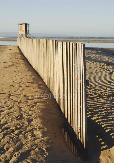 Деревянный забор на песчаном пляже — стоковое фото