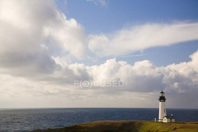 Lighthouse on shore against water, — Stock Photo