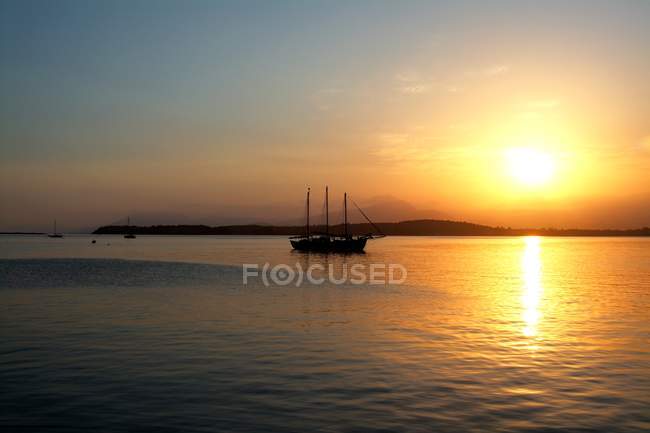 Pôr do sol sobre a baía e barco — Fotografia de Stock