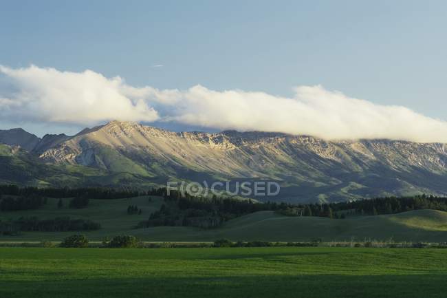Chaîne de montagnes avec collines verdoyantes — Photo de stock