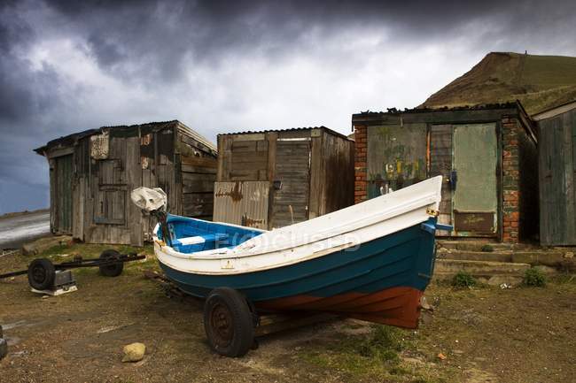 Лодка рядом со старыми мешками — стоковое фото
