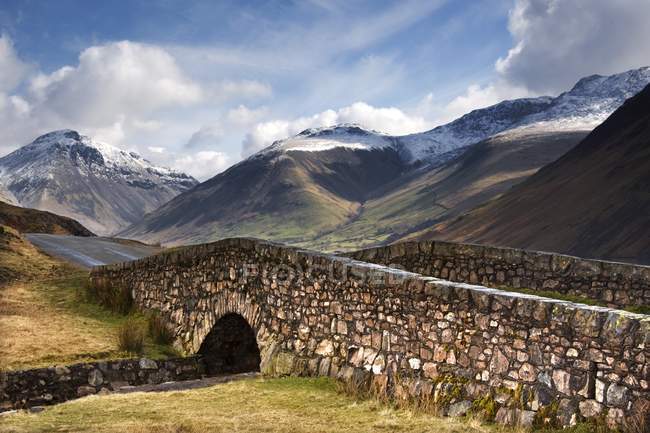 Каменный мост в горном пейзаже — стоковое фото