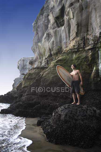 Surfista en la playa Muriwai - foto de stock
