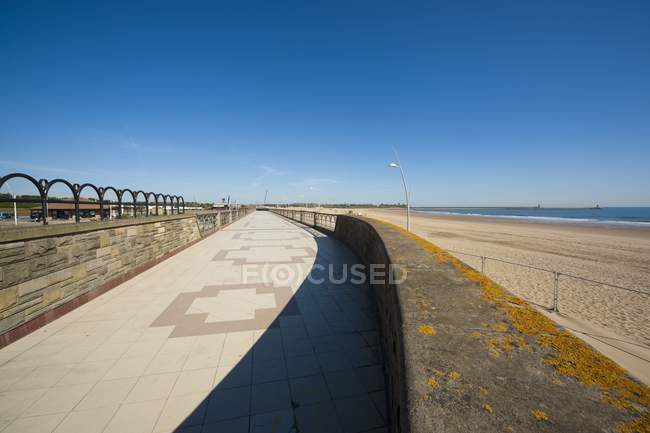 Un marciapiede piastrellato lungo la costa — Foto stock
