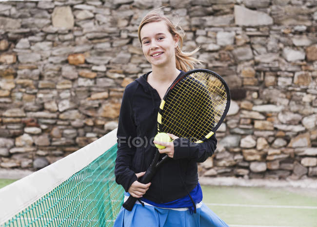 Teenie-Mädchen hält Schläger auf Tennisplatz — Stockfoto