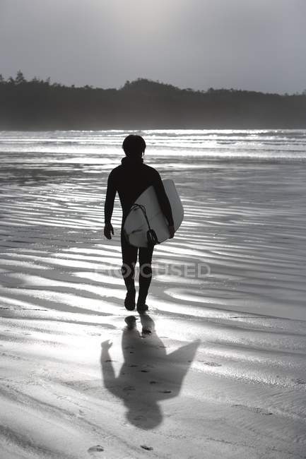 Vue arrière de la promenade des surfeurs sur la plage — Photo de stock
