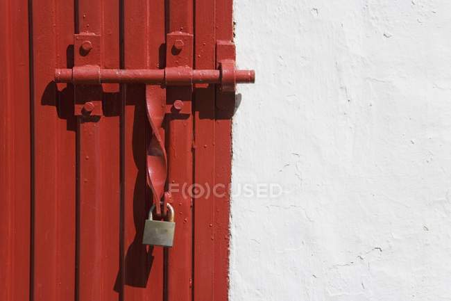 Portão trancado sobre a porta vermelha — Fotografia de Stock