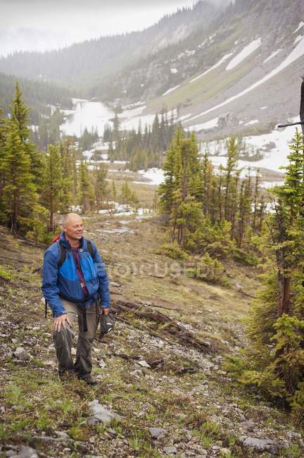 Hombre caminando a través de las montañas - foto de stock