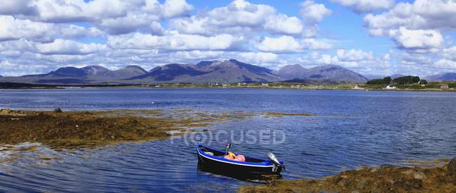 Boat in water against coast — Stock Photo
