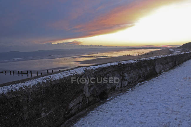 Muro di mare in inverno al tramonto — Foto stock